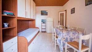 A compact room with a bed, a dining table, and a small kitchenette. - Residence La Valdana - 3 room apartment with swimming pool, tennis and parking 1km from the beach (Capoliveri)