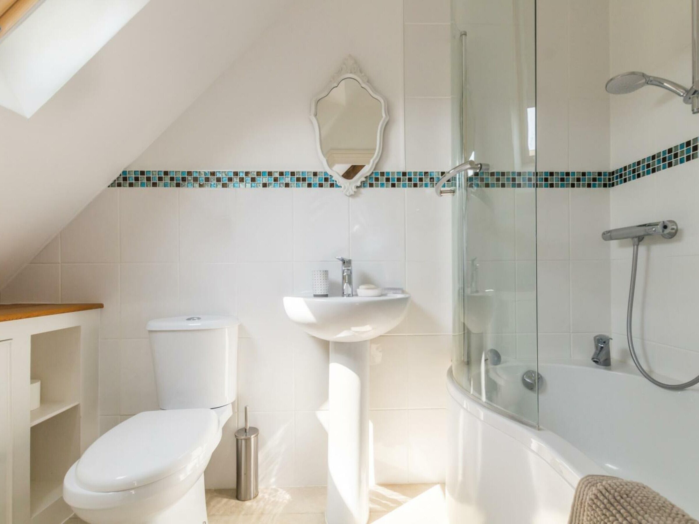 Un baño moderno con inodoro, lavamanos y ducha.