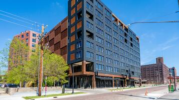 A modern multi-story hotel with a mix of glass and brick facades, large windows, and a visible entrance with a sign.