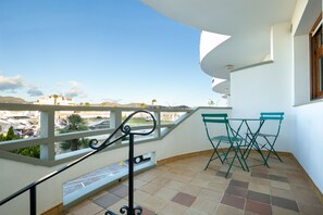 A balcony with a view of a cityscape, a railing, and two green chairs. - V005 - Cargols de Mar 5, Casa en residencia privada con piscina delante de la playa. (Empuriabrava)