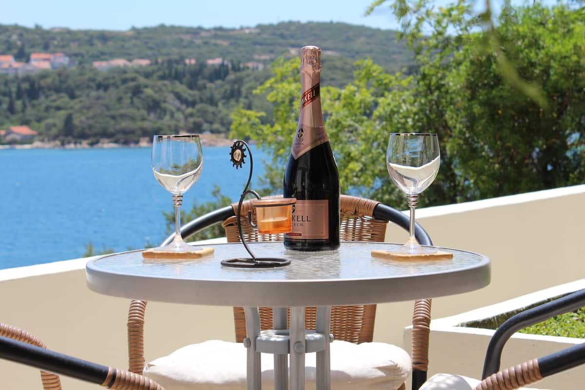 A table with a bottle of Kell wine, two glasses, and a coaster.