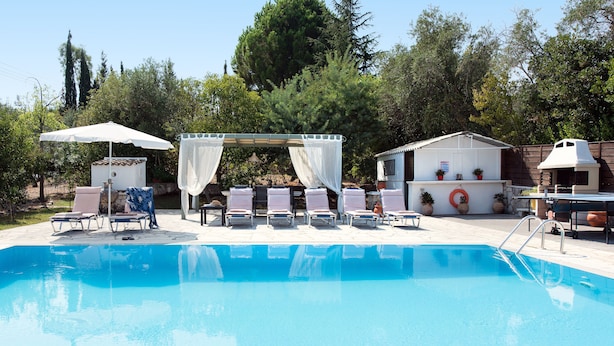 A swimming pool with lounge chairs and a canopy. - Villa Cesar (Corfu)