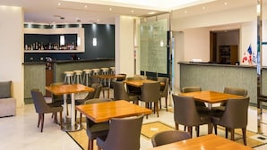 A modern restaurant with multiple tables and chairs, a bar area with bottles, and a counter with flags. - Di Palai Hotel (Zakynthos)