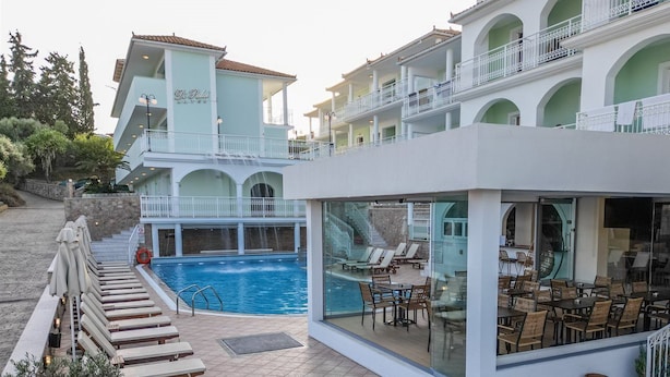 A hotel with a pool, outdoor seating, and a two-story building with balconies. - Di Palai Hotel (Zakynthos)