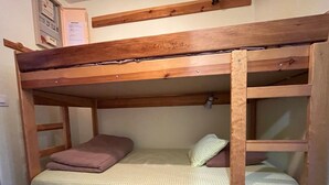A bunk bed with two levels, wooden headboard, and a small shelf on the lower bunk. - 28m² Studio at the slopes base, 4 pax, Les Cimes residence (Enchastrayes)