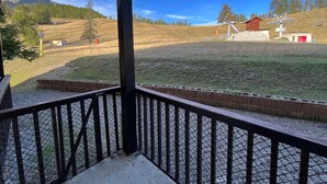 A covered outdoor area with a metal railing, a grassy field, and a mountain in the background. - 28m² Studio at the slopes base, 4 pax, Les Cimes residence (Enchastrayes)