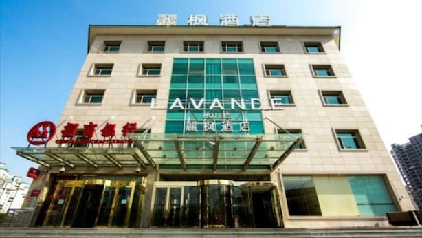 Un hotel con fachada moderna, una entrada de cristal destacada y señalización que indica que es un hotel.