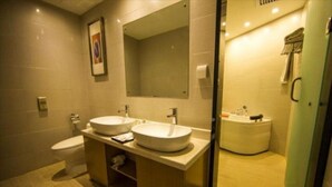Un baño moderno con dos lavamanos, un inodoro y una zona de ducha.