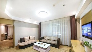 Una sala de estar moderna con dos sofás, una mesa de centro y un televisor en la pared.