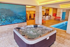 A hot tub, a pool, and a reception area with a bench and chairs. - Blue Sea Beach Resort (Rhodes)