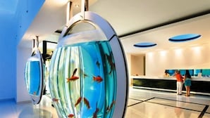 A modern hotel lobby with a large aquarium display featuring fish.