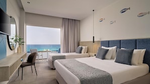 A hotel room with two beds, a desk, a chair, and a large window with a view of the sea.