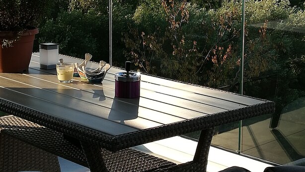 Un patio con mesa y sillas, con vista a un paisaje montañoso.