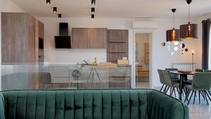 Una cocina moderna con una isla de vidrio, armarios de madera e iluminación colgante.