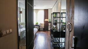 A hotel room with a bed, bedside table, lamp, and a view of the hallway. - Yuetu International Hotel (Shangrao)