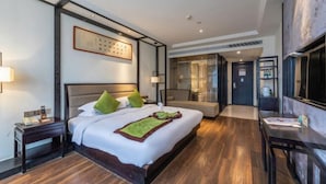 A hotel room with a large bed, a desk, and a TV. - Yuetu International Hotel (Shangrao)