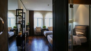 A modern hotel room with a wooden floor, two beds, a desk, and a glass partition. - Yuetu International Hotel (Shangrao)