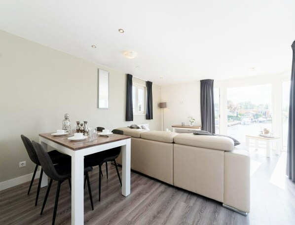 Un espace de vie moderne comprenant un coin repas, un canapé et une vue sur la ville.
