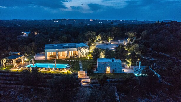 Una casa grande y moderna con piscina, varias habitaciones y un jardín cuidado.