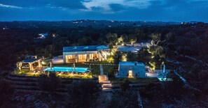 A large, modern house with a swimming pool, multiple rooms, and a well-maintained garden.