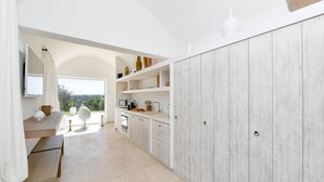 Una cocina moderna con armarios blancos, encimera de madera y vistas al exterior.