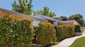A row of modern, single-story buildings with a clean, minimalist design, featuring a concrete pathway and well-maintained greenery. - Mobile Home in Banjole Near Centinera Beach (Medulin)