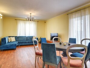 Relax in this inviting living room with a sofa, dining table, and flat-screen TV.