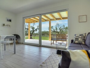 A modern living room with a sliding glass door leading to an outdoor patio.
