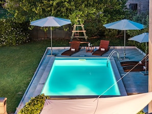 A rectangular swimming pool with a tiled deck, surrounded by lounge chairs and umbrellas. - Apartment With Private Pool in Pula (Pula)