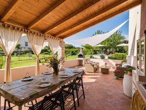 Enjoy al fresco dining on the patio overlooking a serene garden and pool.