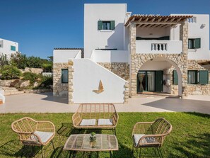 A modern villa with a stone facade, a central archway, and a patio with wicker furniture. - Luxury Villa With Amazing Sea Views, Private Pool, Near the Beach (Chania)