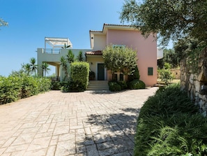 Una casa de dos pisos con un camino pavimentado que conduce a la entrada.