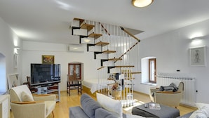A modern living room with a staircase, a television, and seating areas. - Holiday Home Vodnjan With Private Pool (Marcana)