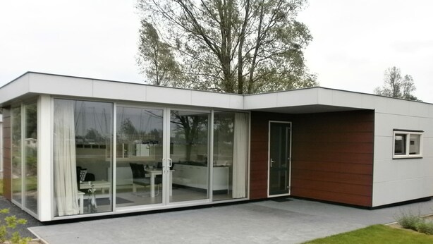 A modern house with a glass sliding door entrance, a small patio, and a wooden exterior. - Modern Chalet With Dishwasher Near Biesbosch (Dordrecht)