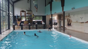 A swimming pool with a ship-themed play structure and a mural of a sailing ship. - Modern Chalet With Dishwasher Near Biesbosch (Dordrecht)