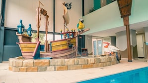 A pool area with a pirate ship play structure, a pelican statue, and a staircase leading to an upper level.