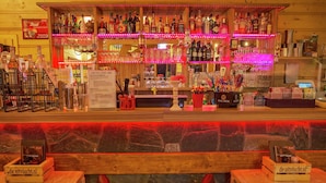 A bar area with multiple shelves of liquor bottles, a menu board, and a wooden counter. - Modern Chalet Near Brunssummerheide (Brunssum)