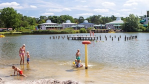 A lakeside setting with a dock, buildings, and a clear sky. - Comfy Chalet With Dishwasher (Mol)