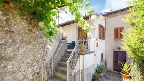 A stone staircase leading to a building with a wooden door and window shutters. - Farmhouse in Casoli Near Ski Slopes (Bagni di Lucca)