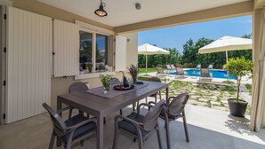 Eine Terrassengruppe mit Tisch, Stühlen und einem Poolbereich.