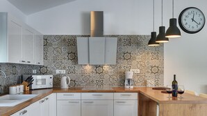 A modern kitchen with white cabinets, a patterned backsplash, and a wooden countertop. - Comfortable Villa With Private Swimming Pool, Table Football, Near Labin (Sveta Nedelja)