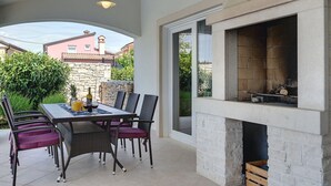 An outdoor patio with a dining table, chairs, and a fireplace. - Comfortable Villa With Private Swimming Pool, Table Football, Near Labin (Sveta Nedelja)