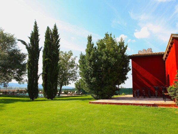 Un edificio rojo con piscina y zona de estar al aire libre.