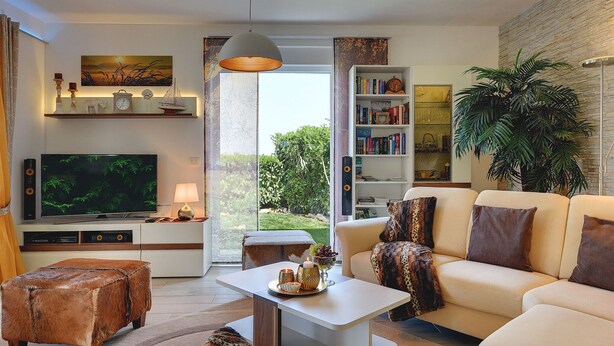 A modern living room with a flat-screen TV, a bookshelf, a sofa, and a coffee table. - Villa in Novigrad With Pool Near Beach (Novigrad)