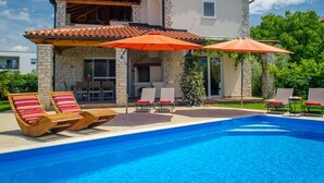 A two-story house with a swimming pool, outdoor seating, and a stone facade. - Villa in Novigrad With Pool Near Beach (Novigrad)