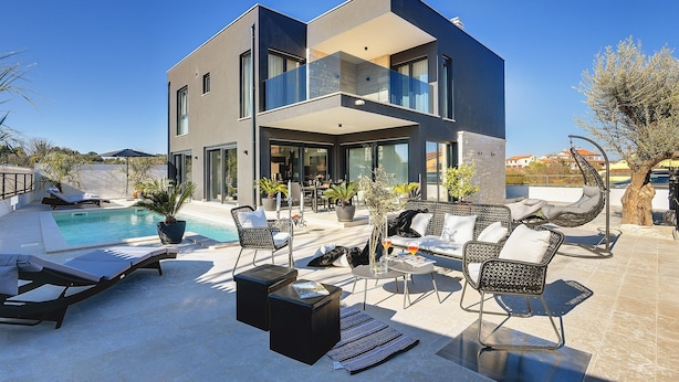 A modern two-story house with a pool, outdoor seating, and a clear blue sky. - Holiday Home in Rovinj With Pool and Sauna (Rovinj)