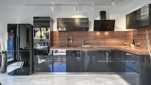 A modern kitchen with a built-in oven, a stainless steel sink, and a wooden backsplash. - Holiday Home in Rovinj With Pool and Sauna (Rovinj)