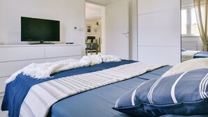 A bedroom with a bed, a television on the wall, and a wardrobe. - Boutique Villa in Peroj With Garden (Vodnjan)