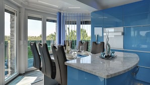 Eine moderne Küche mit blauen Schränken, einer Marmorarbeitsplatte und Blick auf einen Pool.