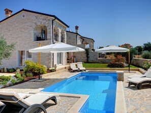 A stone house with a swimming pool, outdoor seating, and umbrellas. - Beautiful Villa With Garden, Private Heated Pool, Whirlpool, Sauna, Near Rovinj (Rovinj)